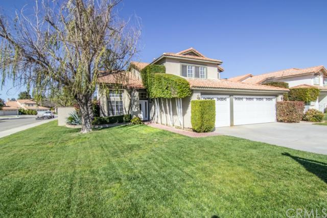a view of a big house with a big yard and large tree