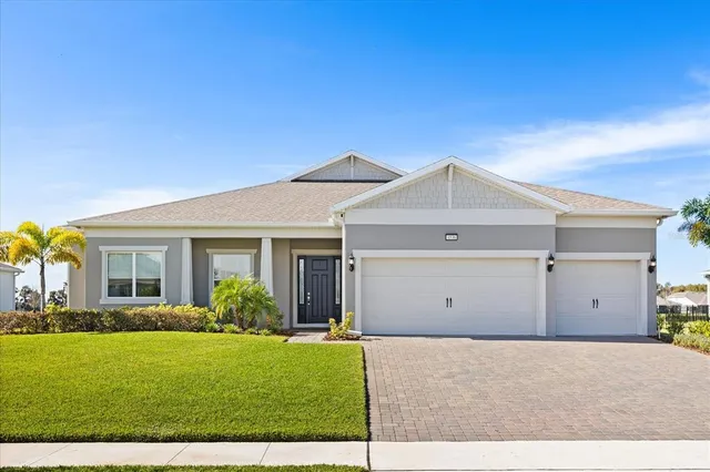 a view of a house with a yard and potted plants