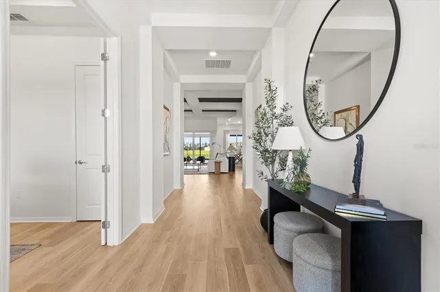 a living room with furniture kitchen view and a wooden floor