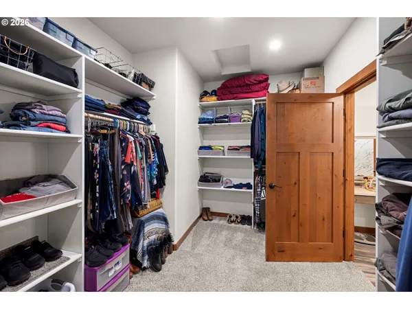 a view of walk in closet with clothes and shoes
