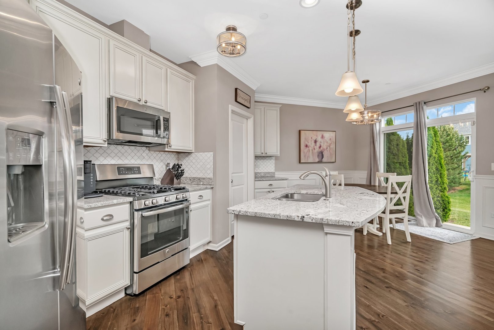 16127 West Switch Grass Road Lockport, IL 60441 - Photo 6 of 19 a kitchen with stainless steel appliances granite countertop a stove top oven a sink dishwasher a refrigerator with a dining table and chairs with wooden floor