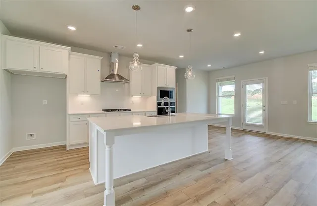 a open kitchen with white cabinets and wooden floor