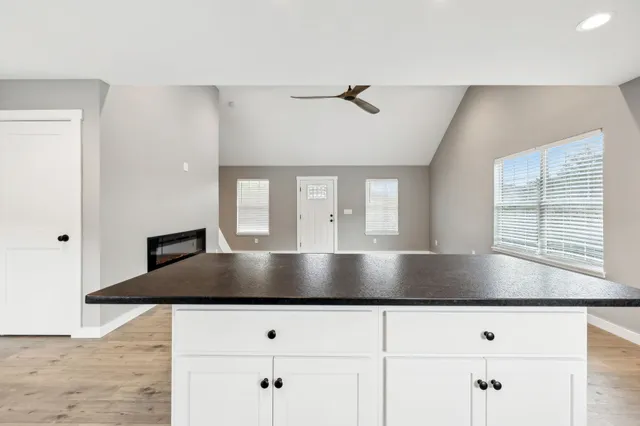a kitchen with granite countertop a stove a counter space and a window