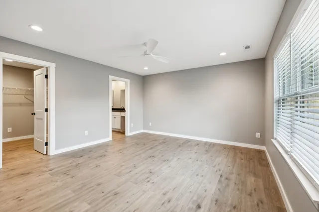 an empty room with wooden floor and windows