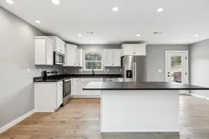 a kitchen with stainless steel appliances granite countertop a stove a sink and a microwave