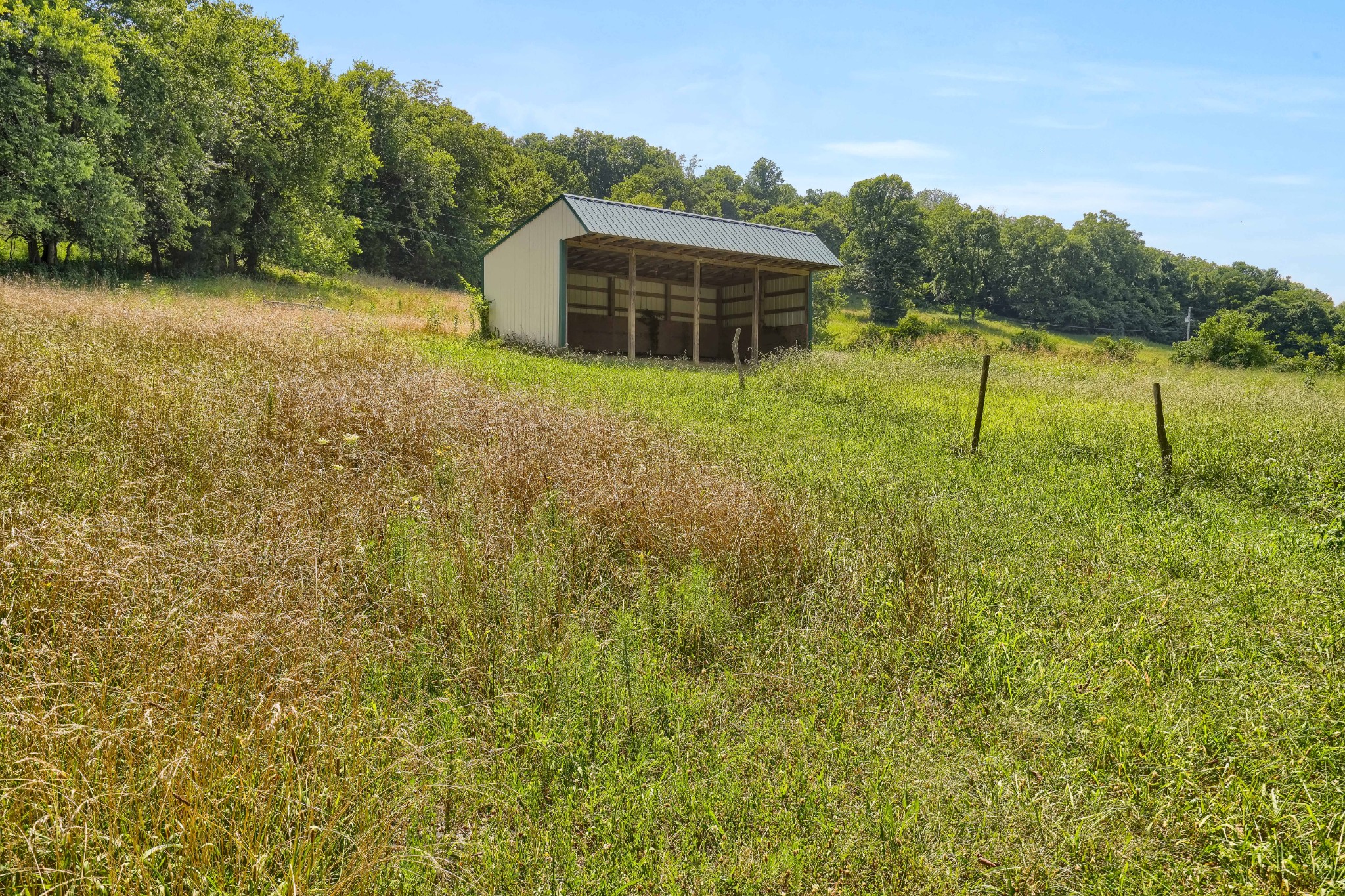 911 Petersburg-Chestnut Ridge Road Petersburg, TN 37144 - Photo 30 of 57 a backyard of a house with lawn chairs under an umbrella