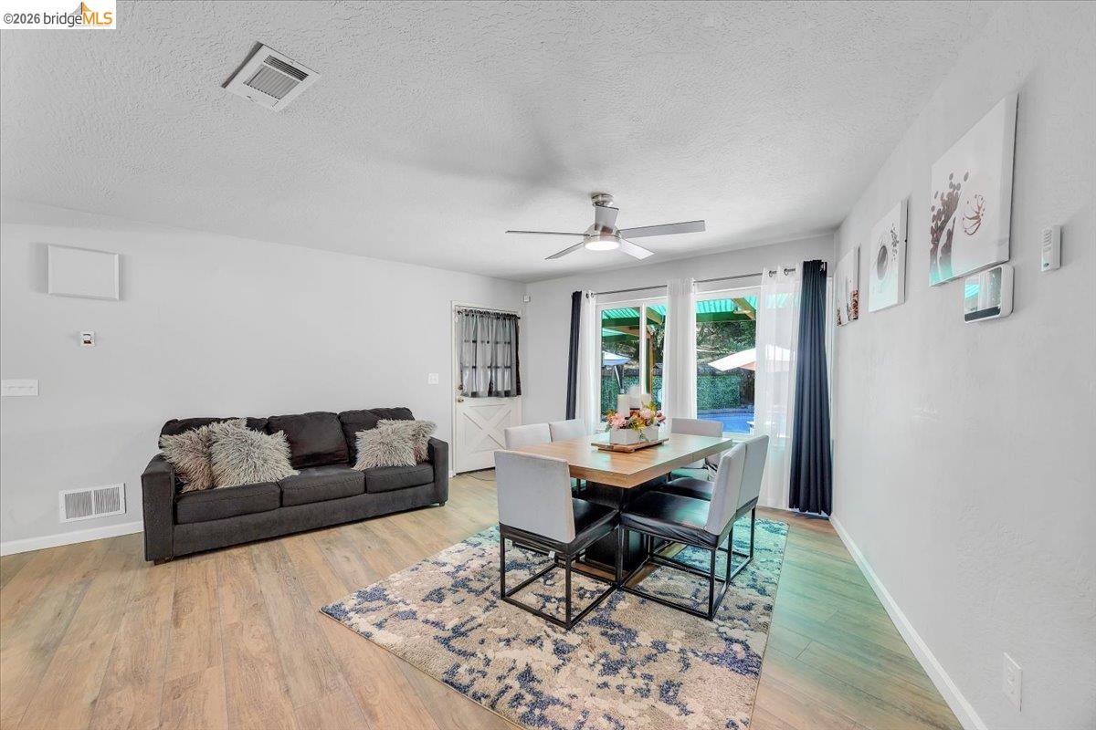 8733 Fraguero Road Sonora, CA 95370 - Photo 37 of 73 Open-concept living and dining area featuring wood-finish flooring, a ceiling fan with integrated lighting, and white walls