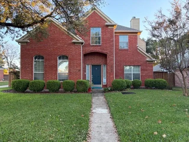 a front view of a house with yard and green space