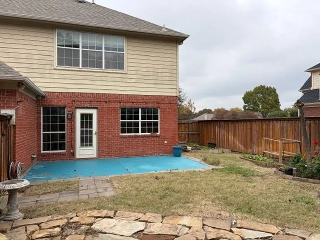 a backyard with wooden fence and a bench