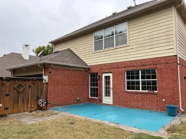 a sign that is sitting on a brick wall with large trees