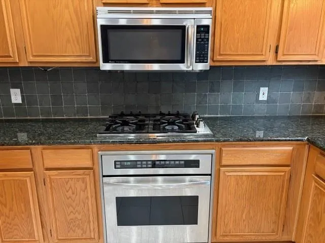 a stove top oven sitting inside of a kitchen