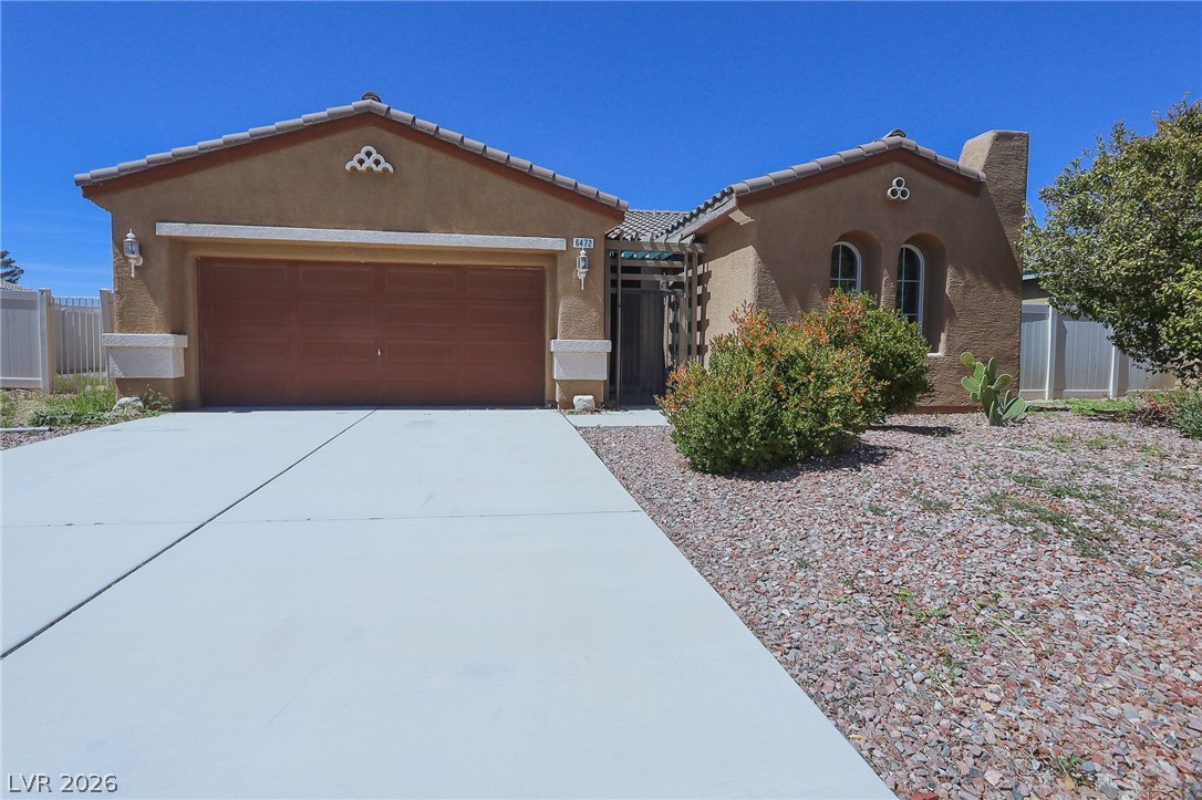 A well-maintained stucco facade with an attached garage welcomes you home.