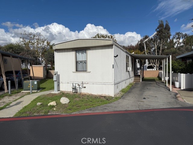 a view of a white house with a small yard and potted plants