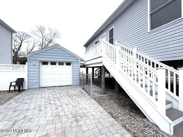 a view of a house with wooden stairs and a small yard