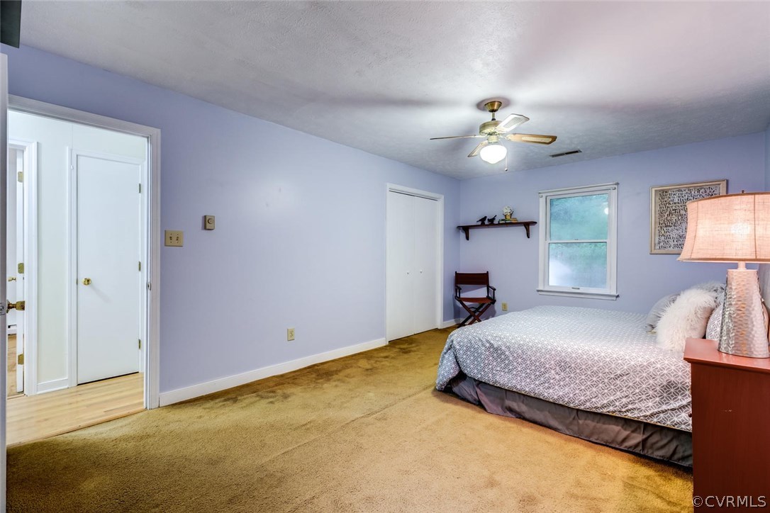 7413 River Road Hanover, VA 23069 - Photo 17 of 30 a bedroom with a bed and a chandelier