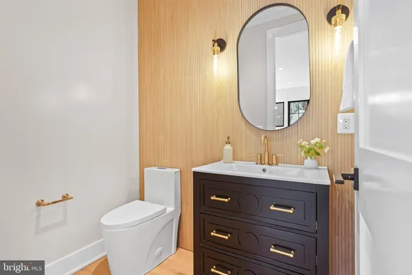 a large white kitchen with a stove a chandelier a dining table and chairs