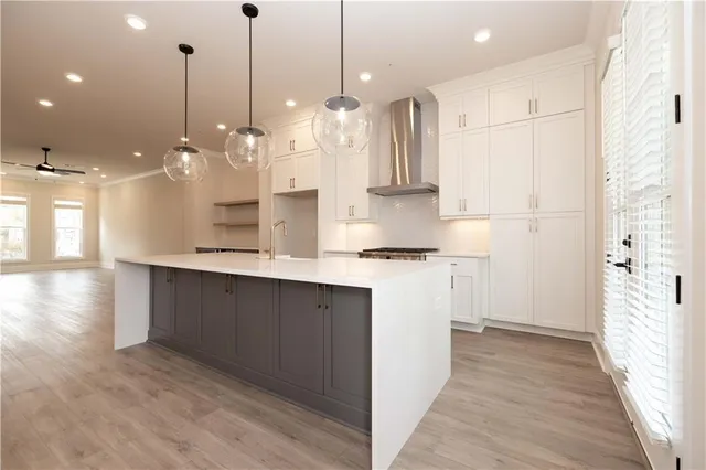 a large kitchen with kitchen island white cabinets and stainless steel appliances