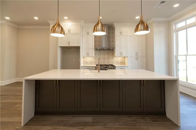 a kitchen with a sink a window and chairs