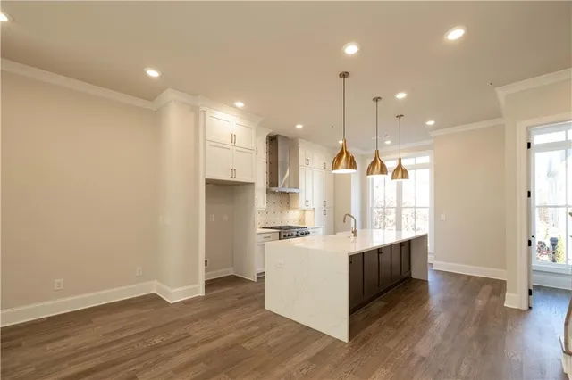 a kitchen with stainless steel appliances granite countertop a refrigerator a sink and a stove