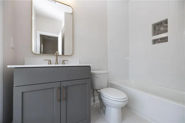 a bathroom with a toilet a sink a mirror and vanity