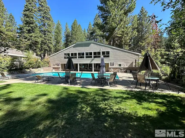 a view of a house with backyard and sitting area