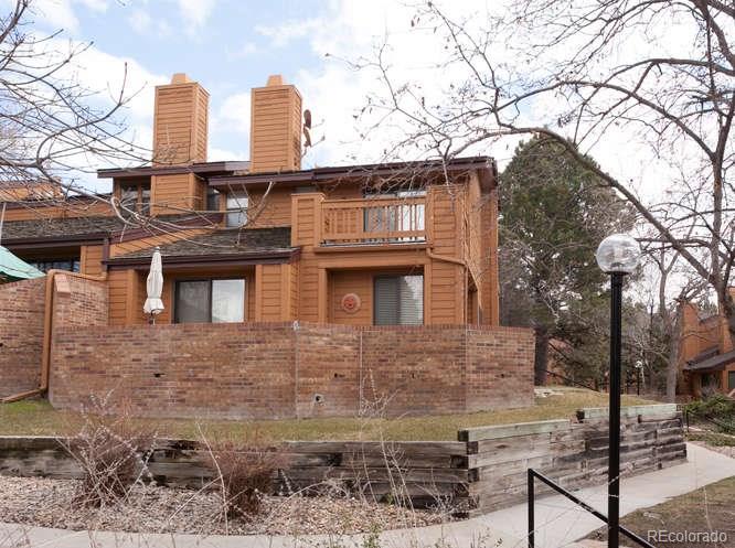 a view of a brick house with large windows and a tree