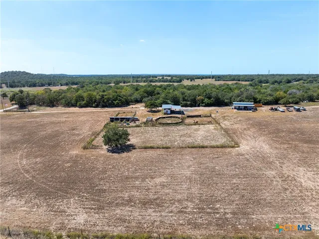 a view of a dry yard with wooden fence