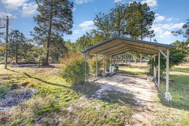 a view of a house with backyard and trees