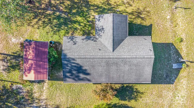 an aerial view of a house with a yard and large trees