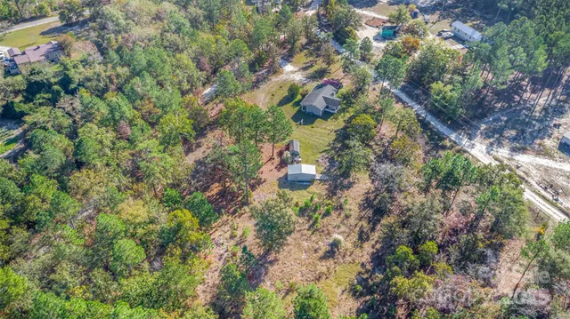 a backyard of a house with a yard and large trees