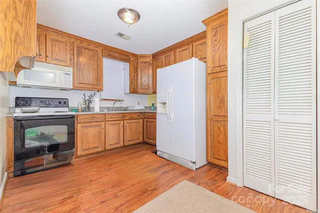 a kitchen with a sink a refrigerator and cabinets