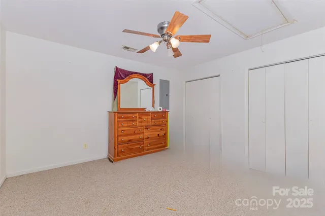 an empty room with closet and fan