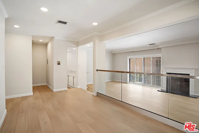 a view of empty room with wooden floor and fireplace
