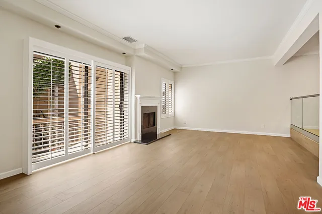 a view of an empty room with a fireplace and a window