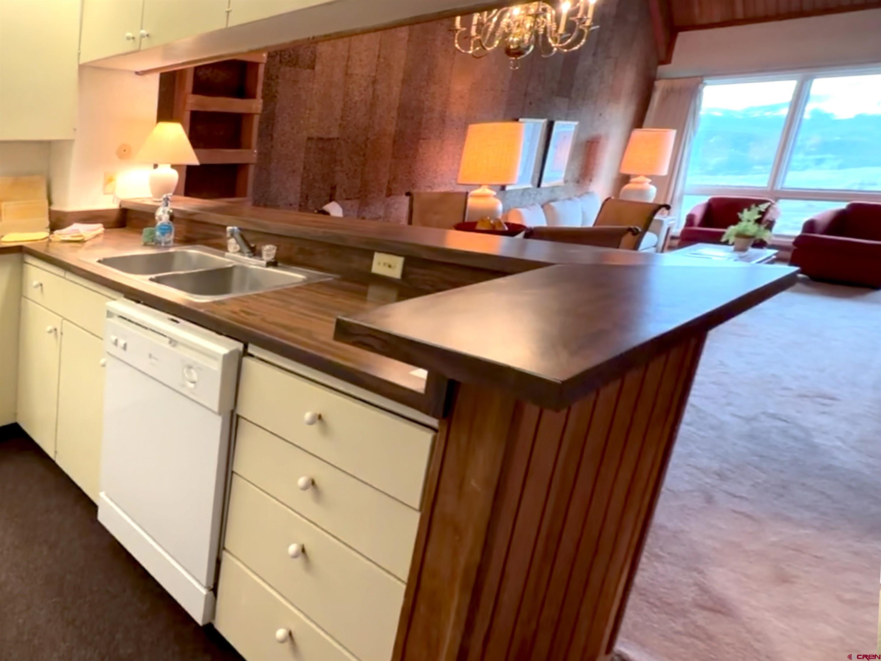 51 Whetstone Road, Unit 2306 Crested Butte, CO 81225 - Photo 20 of 44 a kitchen with stainless steel appliances a sink dishwasher stove and microwave with wooden floor