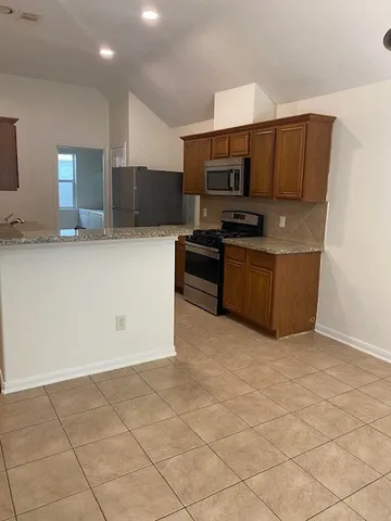 a view of kitchen with stainless steel appliances cabinets