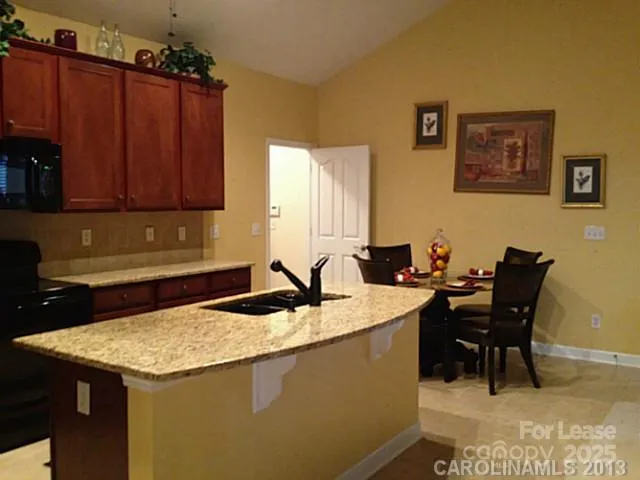 a kitchen with a refrigerator and a stove top oven