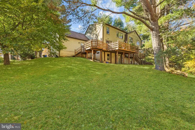 a view of a big house with a big yard and large trees