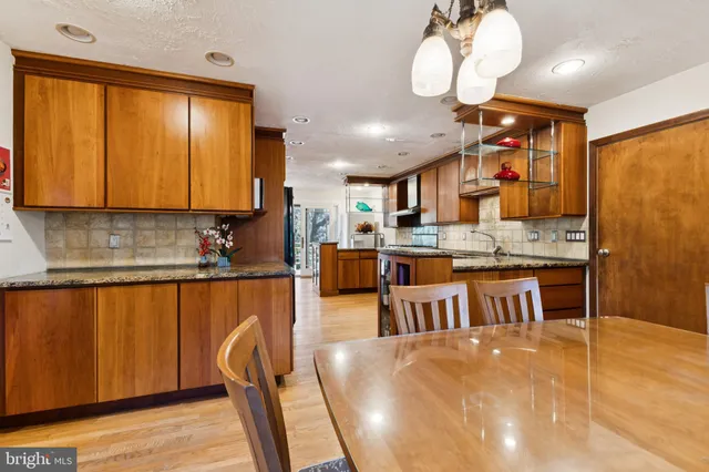 a kitchen with stainless steel appliances granite countertop a stove top oven a sink dishwasher and cabinets with wooden floor