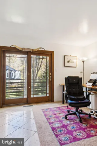 a living room with furniture a rug and a floor to ceiling window