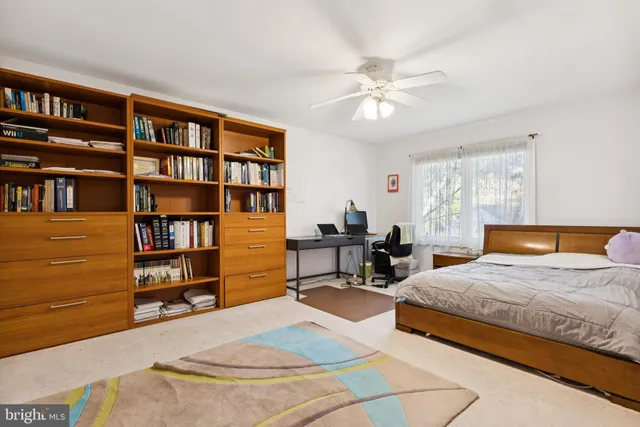 a bedroom with a bed furniture and a book shelf