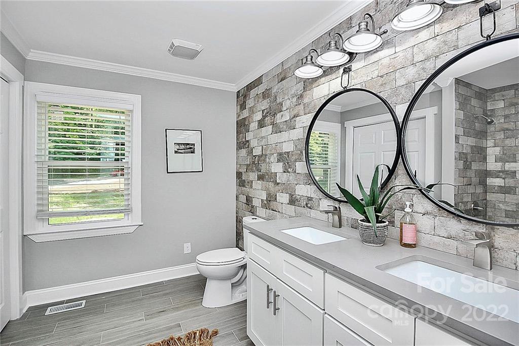 225 Morning Dale Road Matthews, NC 28105 - Photo 27 of 48 a spacious bathroom with a granite countertop toilet a sink and a mirror