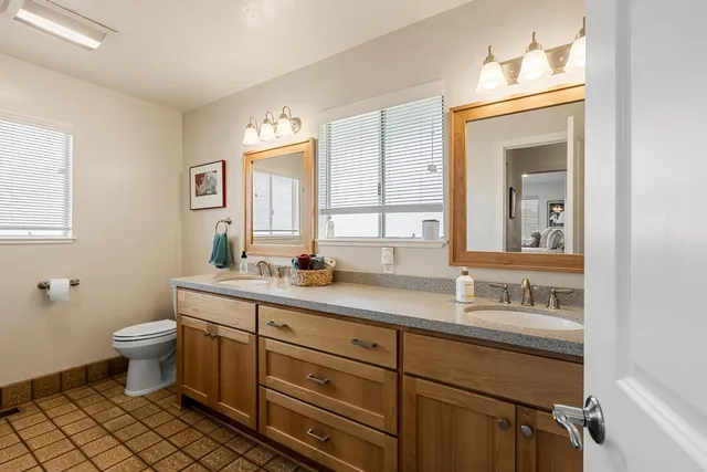 a bathroom with a toilet sink and mirror