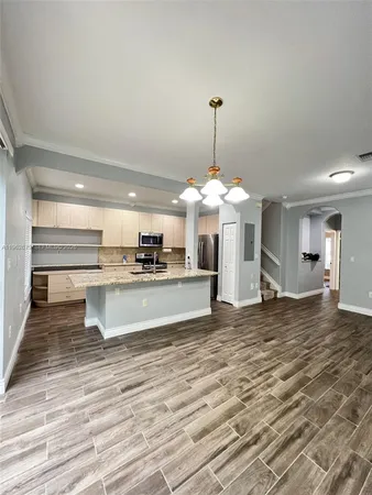 a view of a kitchen with granite countertop a stove and a wooden floor