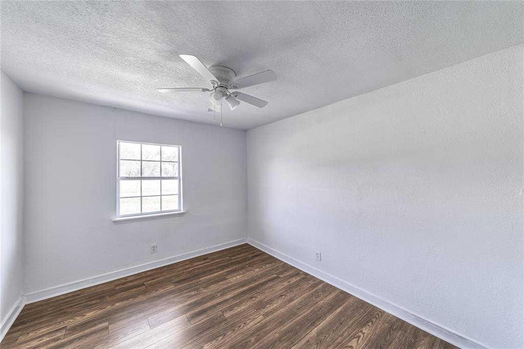 500 County Road 3724 Wills Point, TX 75169 - Photo 17 of 32 an empty room with wooden floor fan and windows