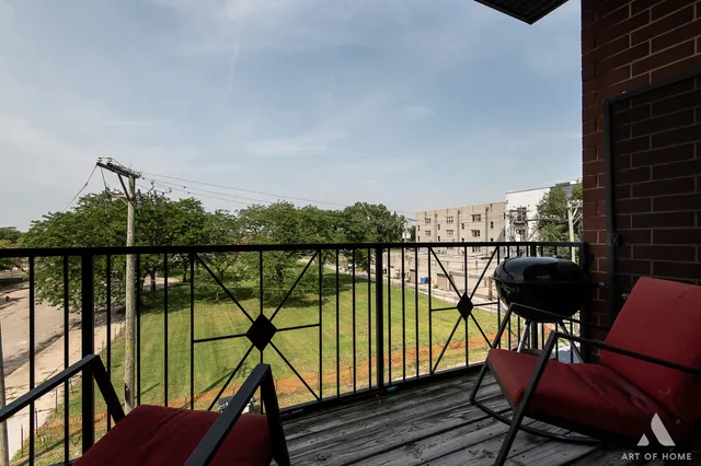 a view of a balcony with chairs and wooden floor