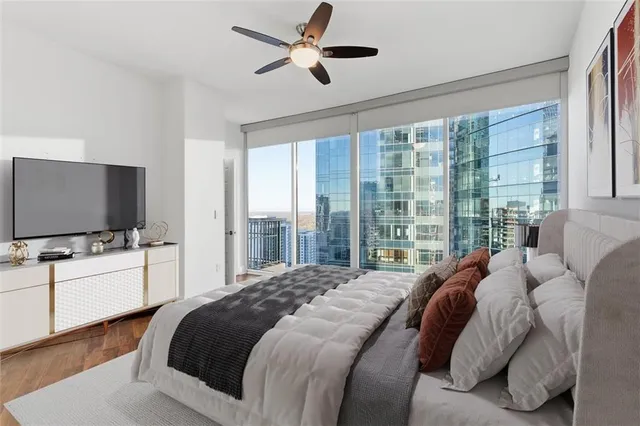 a large bedroom with a bed and a flat screen tv