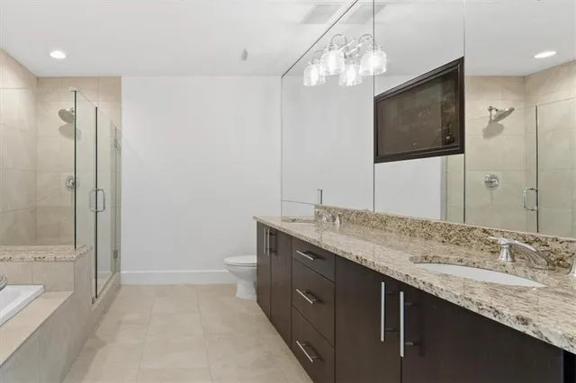 a bathroom with a granite countertop sink a mirror and a bathtub