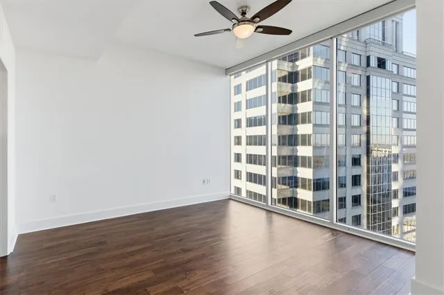 a view of a big room with wooden floor and windows