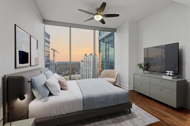 a bedroom with a large bed and a flat tv screen